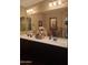 Modern bathroom with double sinks, plenty of storage, and a large vanity mirror at 10773 W Prickly Pear Trl, Peoria, AZ 85383