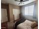Comfortable bedroom with a four-poster bed, ceiling fan, and double door closet at 10773 W Prickly Pear Trl, Peoria, AZ 85383
