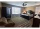 Cozy main bedroom features a ceiling fan, large window, and dark wood furniture at 10773 W Prickly Pear Trl, Peoria, AZ 85383