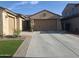 Attached two-car garage with extended driveway, enhanced by brick-lined walkway and green turf at 10773 W Prickly Pear Trl, Peoria, AZ 85383