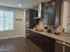Well-equipped kitchen showcasing stainless steel appliances, granite countertops, and dark wood cabinetry at 10773 W Prickly Pear Trl, Peoria, AZ 85383