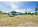 Expansive backyard with a well-maintained lawn, mature trees, and a view of the home's exterior at 10873 W Clair Dr, Sun City, AZ 85351