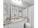 Bathroom features white cabinets, marble countertops, and tile floors at 10873 W Clair Dr, Sun City, AZ 85351