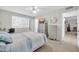 Bright bedroom featuring carpet, window, dresser, and TV, creating a cozy and inviting space at 10873 W Clair Dr, Sun City, AZ 85351