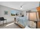 Bright bedroom with a classic wooden bed frame, modern decor, and a window overlooking a tree-lined street at 10873 W Clair Dr, Sun City, AZ 85351
