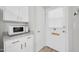 Bright entryway with a white door and white cabinets with stainless steel handles at 10873 W Clair Dr, Sun City, AZ 85351