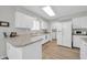 Well-lit kitchen with white cabinets, modern appliances, and ample counter space for meal preparation at 10873 W Clair Dr, Sun City, AZ 85351