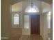 Foyer featuring a decorative front door, tile flooring, and arched entryways to other rooms at 11109 W Amelia Ave, Avondale, AZ 85392