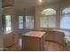 Open concept kitchen with neutral tile flooring, countertops, an island, and large windows with natural light at 11109 W Amelia Ave, Avondale, AZ 85392