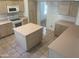 Well-lit kitchen featuring ample countertop space, a center island, a tile floor, and modern appliances at 11109 W Amelia Ave, Avondale, AZ 85392
