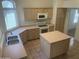 Bright kitchen featuring an island, ample cabinet space, neutral countertops, and modern appliances at 11109 W Amelia Ave, Avondale, AZ 85392