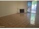 Living room with fireplace and sliding glass door to the backyard, complemented by neutral-toned tile flooring at 11109 W Amelia Ave, Avondale, AZ 85392