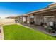 Inviting backyard featuring an artificial lawn, covered patio and cozy seating area at 11312 E Newcastle Ave, Mesa, AZ 85209