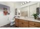 Traditional bathroom featuring wood cabinetry, a large mirror, and a window at 11312 E Newcastle Ave, Mesa, AZ 85209
