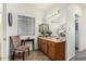 Bathroom featuring a mirror, wood vanity, and a glass block window at 11312 E Newcastle Ave, Mesa, AZ 85209