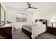 This bright bedroom features a decorative quilt, window, and ceiling fan at 11312 E Newcastle Ave, Mesa, AZ 85209