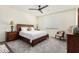 Bedroom featuring a dark wood bed frame, carpeted floors, and ceiling fan at 11312 E Newcastle Ave, Mesa, AZ 85209
