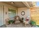 Covered patio with neutral color palette, two comfortable chairs, and stylish decor at 11312 E Newcastle Ave, Mesa, AZ 85209