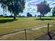 Tranquil golf course view framed by mature trees and a fence, offering a serene outdoor perspective at 11653 N Hacienda Dr, Sun City, AZ 85351
