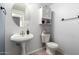 Neat bathroom featuring a pedestal sink, toilet, and cabinet offering essential functionality at 1232 S 120Th Ln, Avondale, AZ 85323