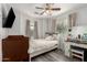 Cozy bedroom with light gray walls, wood floors, a bed, a crib, and a ceiling fan at 1232 S 120Th Ln, Avondale, AZ 85323