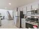Charming kitchen with stainless appliances, gray cabinets, and convenient access to the adjacent staircase at 13438 N 18Th Ln, Phoenix, AZ 85029