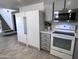 Bright eat-in kitchen with white appliances, gray cabinets and wood-look tile floors at 13438 N 18Th Ln, Phoenix, AZ 85029