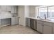 Updated kitchen featuring stainless steel dishwasher, gray cabinets, and view of the backyard at 13438 N 18Th Ln, Phoenix, AZ 85029