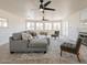 Spacious living room with large windows, ceiling fans, and comfortable gray seating at 13438 N 18Th Ln, Phoenix, AZ 85029