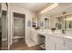 Bright bathroom featuring double sinks, large vanity, and a glass-enclosed shower at 13644 W Aleppo Dr, Sun City West, AZ 85375