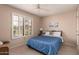 Cozy bedroom featuring a large window, a ceiling fan, and plush carpeting at 13644 W Aleppo Dr, Sun City West, AZ 85375