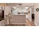 Bright kitchen featuring modern appliances, white cabinetry, breakfast bar and wood flooring at 13644 W Aleppo Dr, Sun City West, AZ 85375