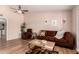 Cozy living room with wood floors, a ceiling fan, and a comfortable brown sofa at 13644 W Aleppo Dr, Sun City West, AZ 85375