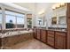Spa-like bathroom with a soaking tub, dual vanities, and ample natural light from a large window at 15020 N 54Th Pl, Scottsdale, AZ 85254