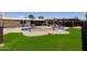 Landscaped backyard boasts a pool with water feature, patio, outdoor kitchen, and artificial turf at 1551 E Glencove St, Mesa, AZ 85203