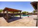 Spacious backyard with an outdoor kitchen, covered patio, and refreshing pool with waterfall feature at 1551 E Glencove St, Mesa, AZ 85203
