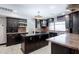 Spacious kitchen featuring dark cabinets, granite countertops, and an elegant Tiffany-style light fixture at 1551 E Glencove St, Mesa, AZ 85203