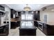Open concept kitchen featuring dark cabinetry, granite countertops, and a stylish central island at 1551 E Glencove St, Mesa, AZ 85203