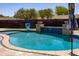 Inviting pool with stone accents, a built-in water feature, and playful basketball hoop at 1551 E Glencove St, Mesa, AZ 85203