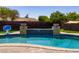A pristine pool features a serene waterfall and a basketball hoop, offering a refreshing outdoor oasis at 1551 E Glencove St, Mesa, AZ 85203
