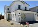 Charming two-story home featuring a gray two-car garage, light green door, and desert landscaping at 1552 N Pueblo Dr, Apache Junction, AZ 85120