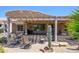 Backyard patio with pergola, outdoor seating, lovely desert landscape, and barbecue grill at 16287 W Willow Creek Ln, Surprise, AZ 85374