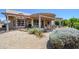 Beautiful backyard patio area featuring a covered pergola, desert landscape, seating, and lush vegetation at 16287 W Willow Creek Ln, Surprise, AZ 85374