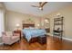 Cozy bedroom with hardwood floors, a ceiling fan, and ensuite bathroom creating a relaxing retreat at 16287 W Willow Creek Ln, Surprise, AZ 85374