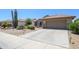 Desert-landscaped home featuring a spacious driveway and low-maintenance curb appeal at 16287 W Willow Creek Ln, Surprise, AZ 85374
