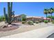 Inviting single-story home with desert landscaping, mature cactus, and a charming tile roof at 16287 W Willow Creek Ln, Surprise, AZ 85374