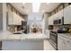 Bright kitchen featuring white cabinetry, granite countertops, stainless steel appliances, and a breakfast bar at 16287 W Willow Creek Ln, Surprise, AZ 85374