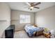 A simple bedroom with a bed, shelves, carpet flooring, and a window with blinds at 17766 W Caribbean Ln, Surprise, AZ 85388