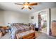 Well-lit main bedroom with a ceiling fan, carpet flooring, and direct access to an ensuite bathroom at 17766 W Caribbean Ln, Surprise, AZ 85388