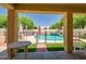 Covered patio providing an unobstructed view of the fenced pool and garden at 17766 W Caribbean Ln, Surprise, AZ 85388